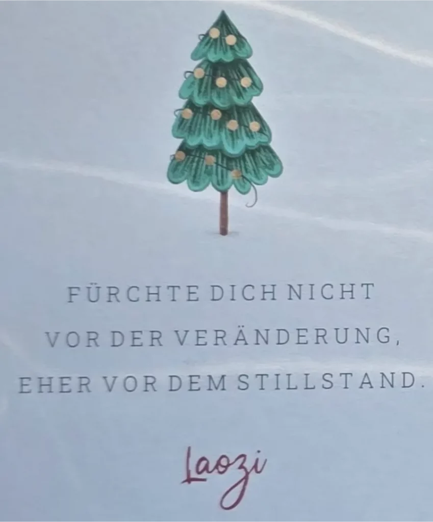Das Bild zeigt auf blauem Hintergrund einen geschmückten Weihnachtsbaum. Text: "Fürchte Dich nicht vor der Veränderung, eher vor dem Stillstand. Laozi".
