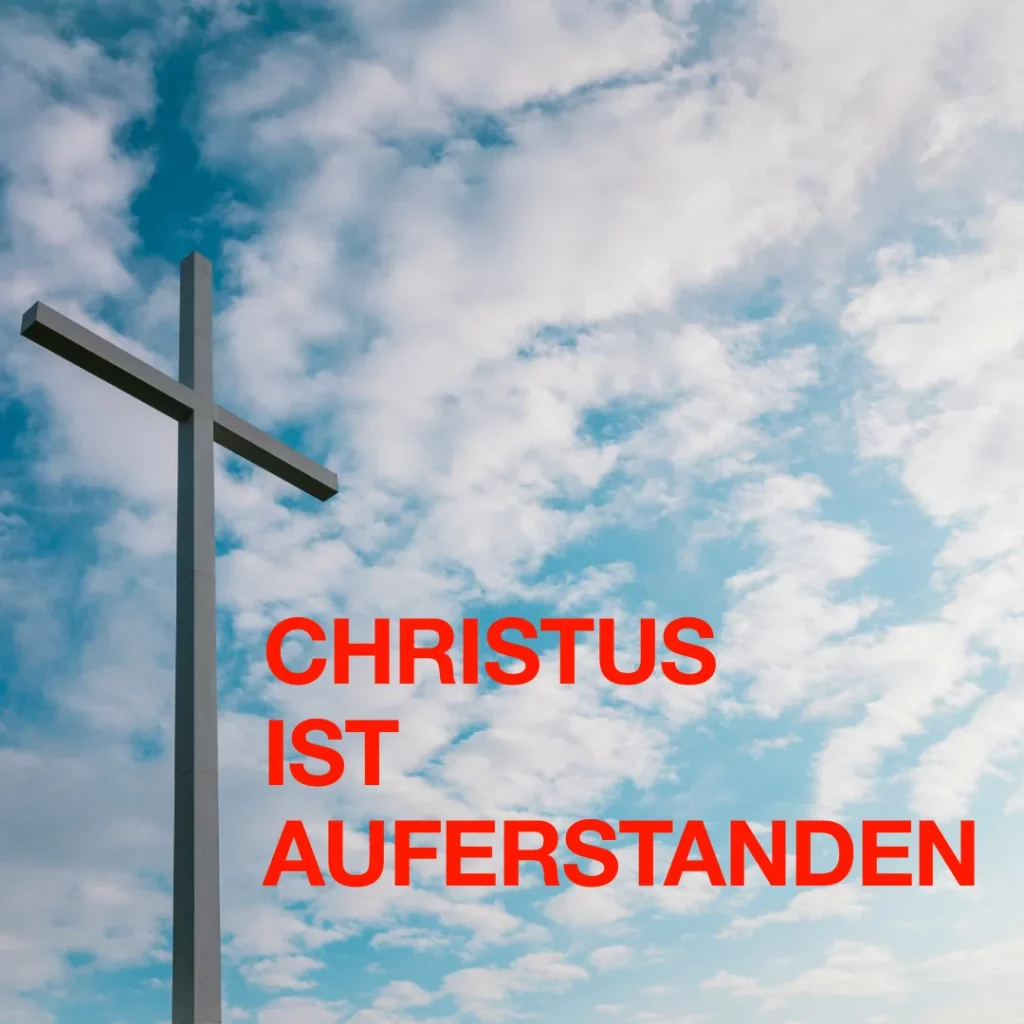 Das Bild zeigt vor blau-weißem Himmel auf der linken Hälfte ein schlichtes Kreuz. Text: "Christus ist auferstanden".
